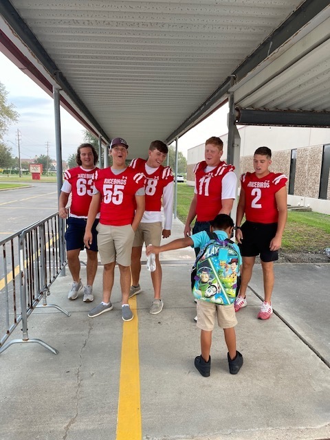 football players with an elementary student
