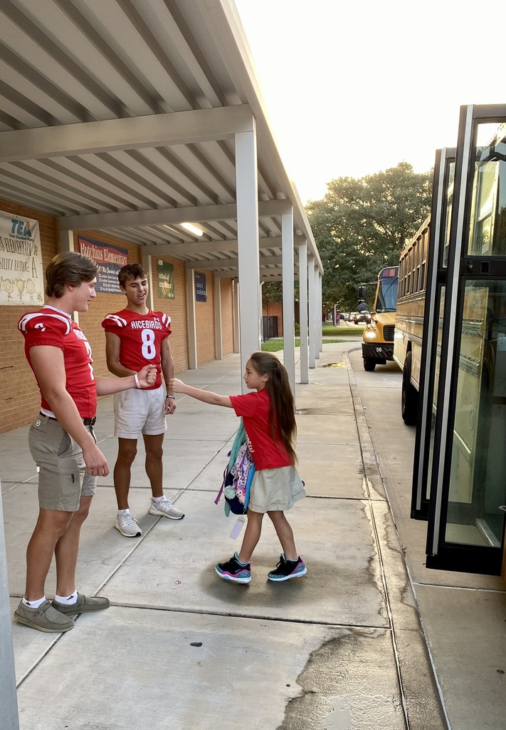 football players greeting an elementary student