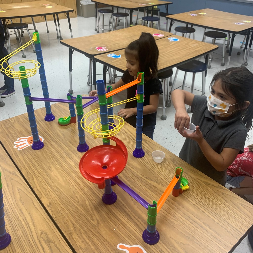 children putting marbles in a marble run