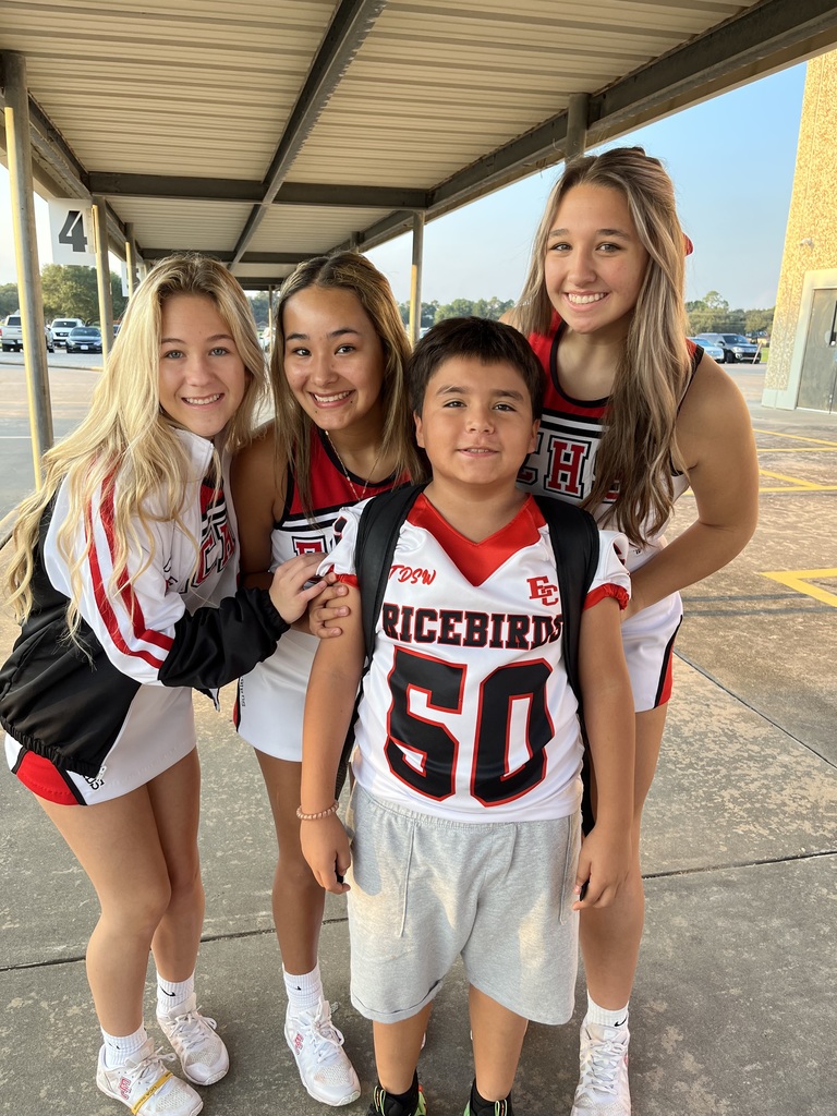cheerleaders with elementary student at drop off