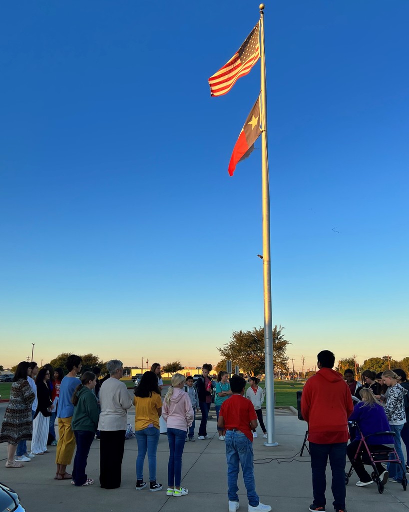 students praying around the flag pole