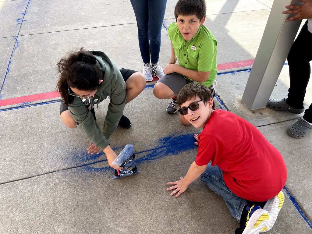 3 students with blue chalk