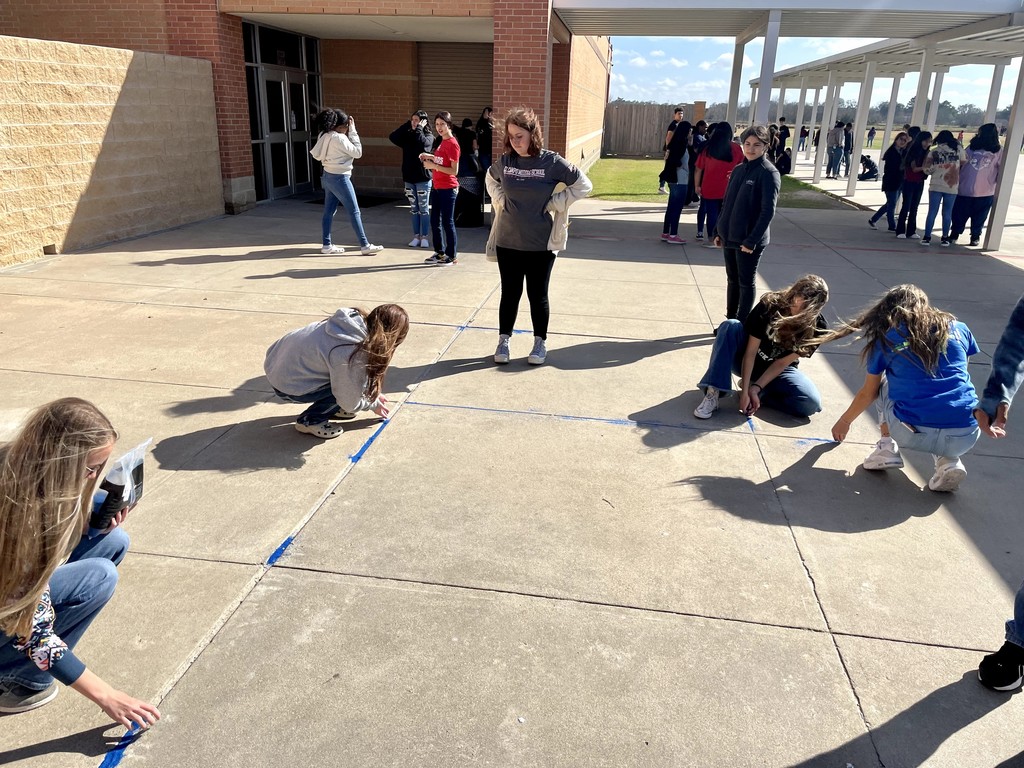 several students outside with blue chalk