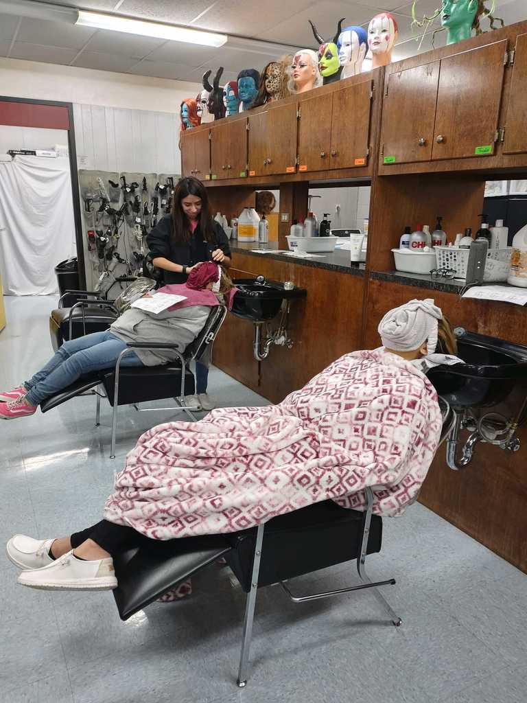students laying in chair with a damp towel on their face