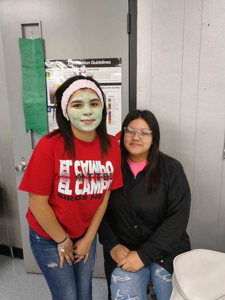 a student with a facial mask standing with her aesthetician in the making
