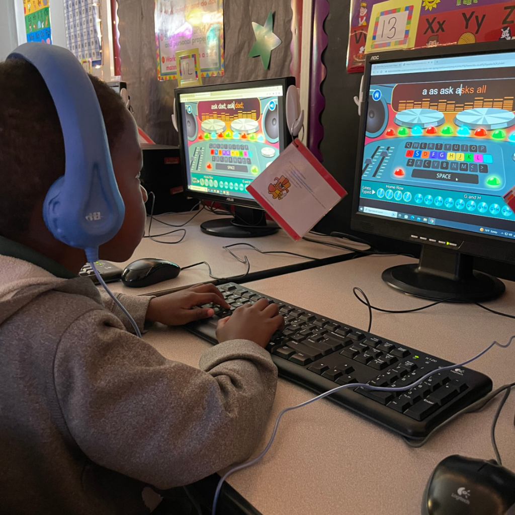 student typing on keyboard at computer